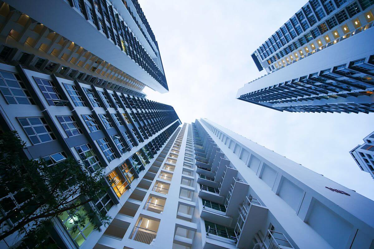 Modern high-rise residential condominium towers viewed from below, highlighting contemporary architecture and urban living.