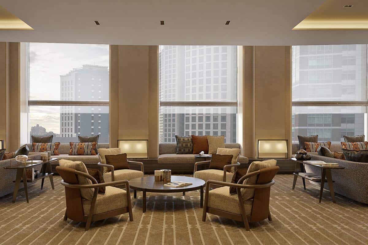 Elegant residential lounge with comfortable seating and floor-to-ceiling windows overlooking the surrounding cityscape