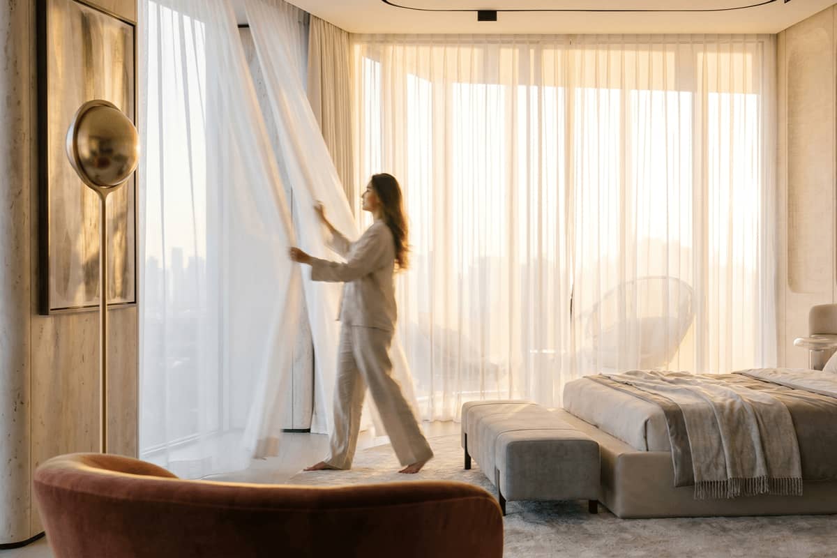 Elegant luxury bedroom with floor-to-ceiling windows, soft natural light, and refined contemporary interiors